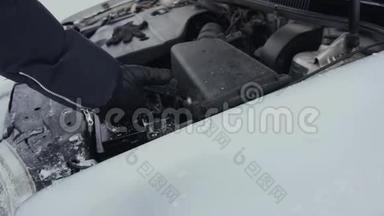 冬季白天停车<strong>时</strong>，人们从车上取下已放电的汽车电池进行修理或修理。<strong>发动机</strong>罩或<strong>发动机</strong>罩升起